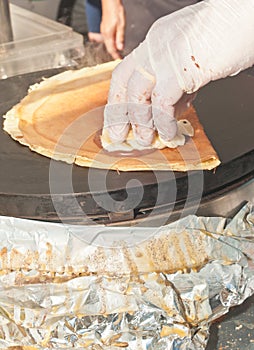 Vender preparing a mushroom filled,French crepe photo