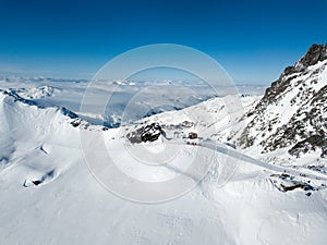 Top gondola drone shot of winter resort with avalanche area