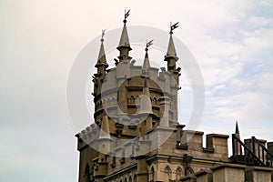 The top of a Gothic castle in close-up against a cloudy sky and