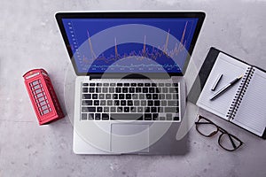 Top of a laptop computer with stock chart market on screen.