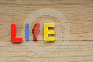Top lay of the word Life on a wooden background photo