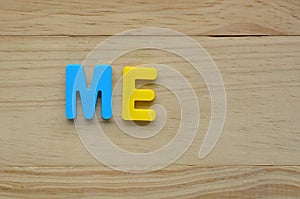 Top lay of the word Me on a wooden background