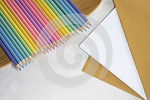 Top left view, Group of color pencil laying in row striaght line on veneer on white and paper background, copy space photo