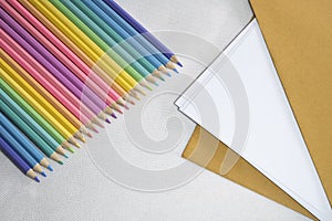 Top left view, Group of color pencild laying in row striaght line made by pencil tips on white and paper background, close up, photo