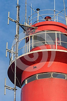 Top of the lighthouse close-up on a background of blue sky.