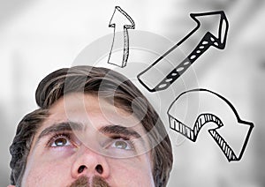 Top of man's head looking up and grey upward arrows against blurry grey stairs