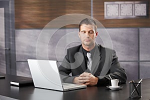 Top manager meditating in elegant office