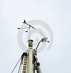 Windex, lanterns and radar reflectors at the top of a mast photo