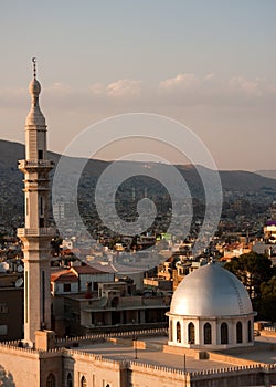 Top of a Mosque minaret and dome against hillside, Damascus