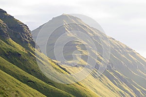 The top of the mountain of Faroe islands. A view of high peaks of mountains on a sunny day. Ocean view.  Beautiful panoramic view.