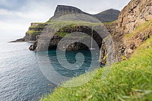 The top of the mountain of Faroe islands. A view of high peaks of mountains on a sunny day. Ocean view.  Beautiful panoramic view.