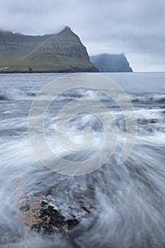 The top of the mountain of Faroe islands. A view of high peaks of mountains on a sunny day. Ocean view.  Beautiful panoramic view.