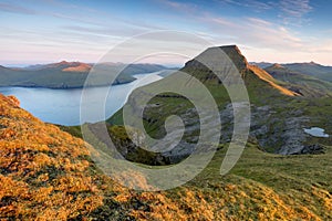 The top of the mountain of Faroe islands. A view of high peaks of mountains on a sunny day. Ocean view.  Beautiful panoramic view.