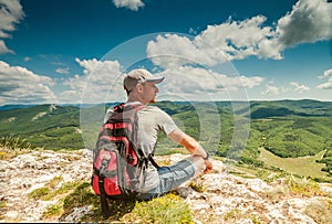 On the top of mountain. Man with backpack enjoyed with mountain