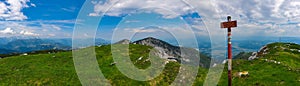 On top of mountain peak Kriznik, Carinthia, border Austria Slovenia. Alpine meadow with scenic view of mountain range Karawanks photo