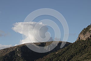 Top of Mountain with Single Puffy Cloud and Blue Sky