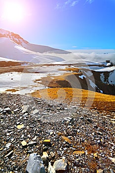 The top of the mountains, snowy peaks, sun, clouds