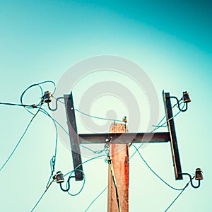 Top old electrical pillar on a background of the blue sky