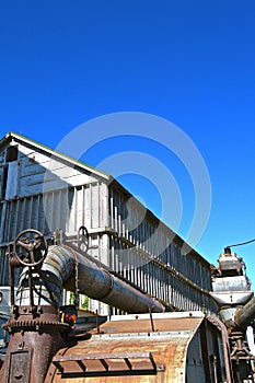 The top of an old threshing machine displays the blower pipe.