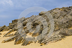 The top of one of the red sandstones with its numerous caves and visible erosion under the cloudy sky photo