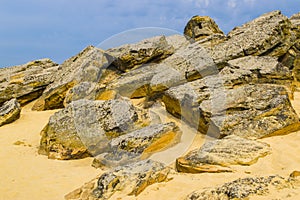 The top of one of the red sandstones with its numerous caves and visible erosion under the cloudy sky photo