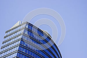 Top part of a blue modern corporate high-rise building with a striped design.