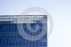 Top part of a glass window wall of an office building.