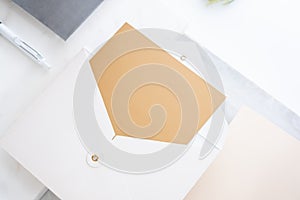 top perspective view of blank golden card in white envelop on two layer step of marble table top.Mock up template for display