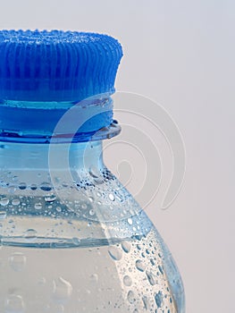 The top of a plastic bottle of clear water is visible on a white background.