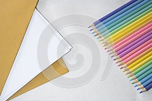 Top right view, Group of color pencild laying in row striaght line made by pencil tips on white and paper background, close up,