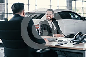 Top sales manager and customer at dealership showroom