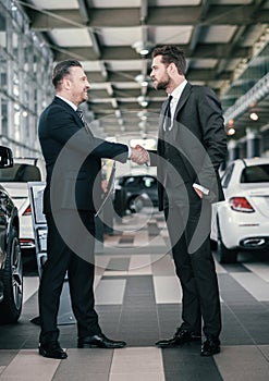 Top sales manager and customer at dealership showroom