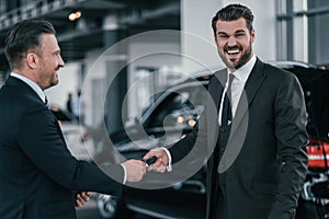 Top sales manager and customer at dealership showroom