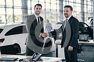 Top sales manager and customer at dealership showroom