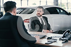 Top sales manager and customer at dealership showroom