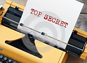 Top Secret on a white sheet of paper in old yellow typewriter