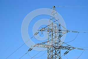 Top section of high-voltage power line metal prop over blue sky