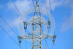 Top section of high-voltage power line metal prop over blue sky