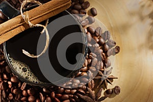 top shot of cup of coffee with cinnamon on wood background