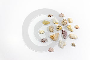 Top shot of several circular right side positioned colorful stones that collected from beach on white background