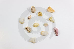 Top shot of several random positioned colorful stones that collected from beach on white background