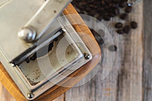Top shot of vitage coffee mill with roasted beans on wooden boards