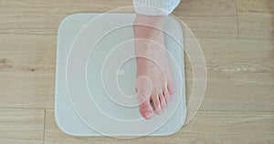 Top shot woman feet standing weighing scales. Concept of dieting, loosing weight and healthy lifestyle. Healthy diet