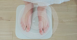 Top shot woman feet standing weighing scales. Concept of dieting, loosing weight and healthy lifestyle. Healthy diet