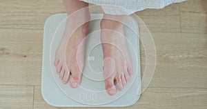 Top shot woman feet standing weighing scales. Concept of dieting, loosing weight and healthy lifestyle. Healthy diet