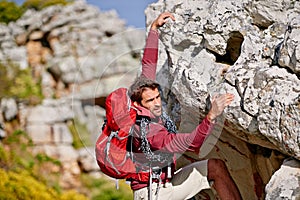 Almost at the top. Shot of a young man enjoying a hike through the mountains.