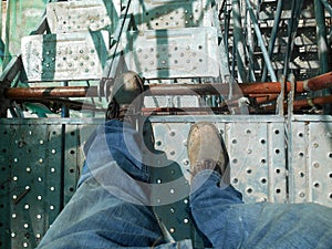 Top or side view of construction worker standing on construction site while wearing safety shoes. The shoes are dirty and dusty.