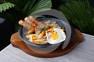 Top Side View Of A Gourmet Filled With Sausages, French Fries, Fried Eggs. On A White Table