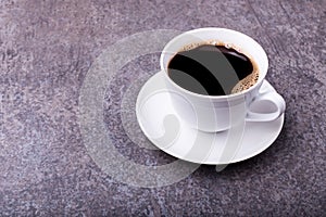 top side view of white porcelain cup with saucer full of coffee, coffee beans