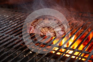 A top sirloin steak flame broiled on a barbecue, shallow depth of field.